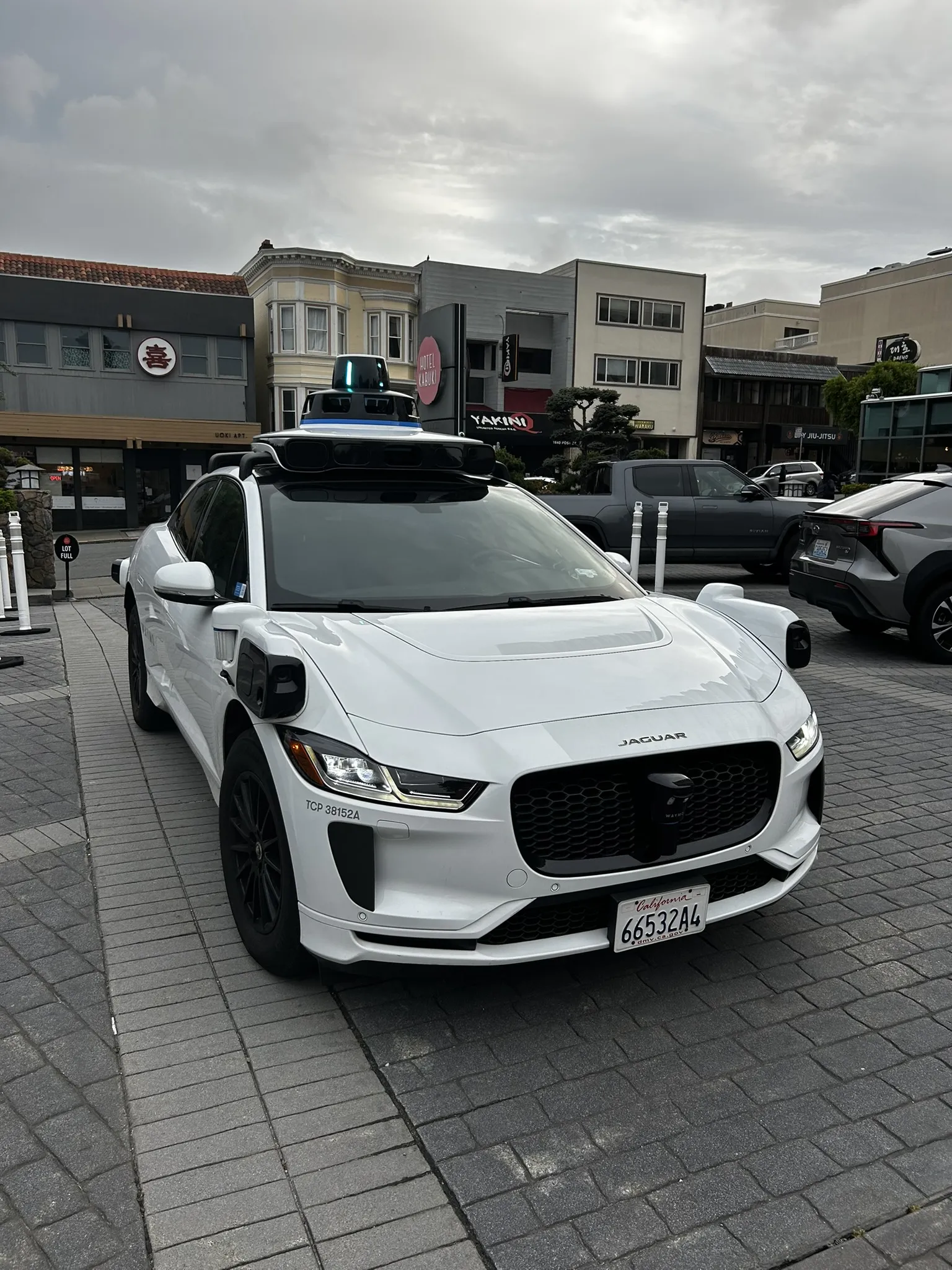 The Waymo Jaguar I-PACE from the front — sensor dome and Jaguar badge visible