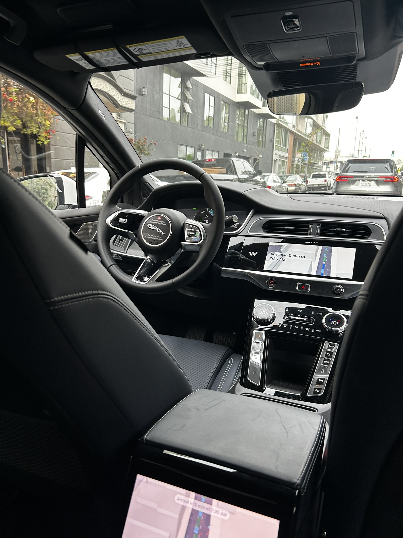 Inside the Waymo — no driver, steering wheel untouched, navigation showing arrival time